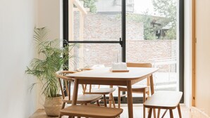 Un coin repas avec une table ronde, des chaises en bois et une plante en pot.