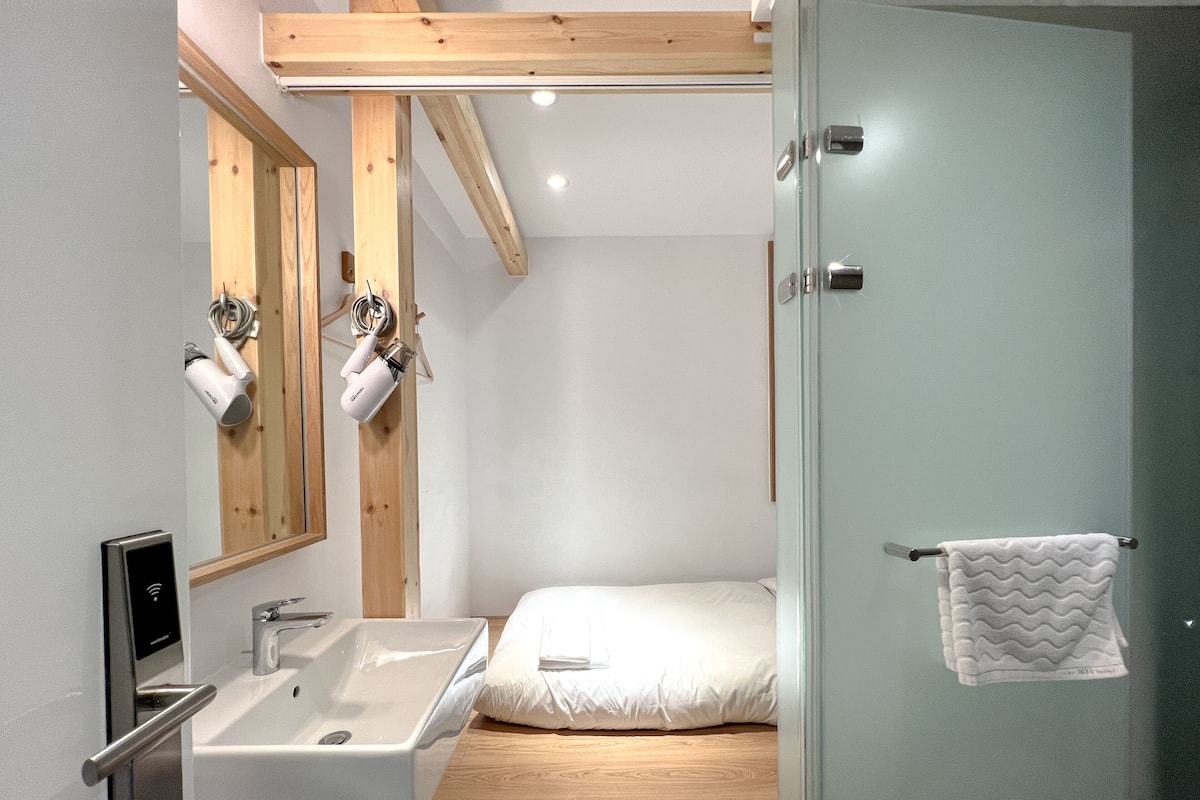 Un baño moderno con lavamanos integrado, espejo y zona de ducha.