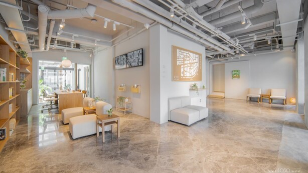 Un intérieur moderne comprenant un vaste espace de détente, une salle de réunion et un coin salon agrémenté d’une carte murale.
