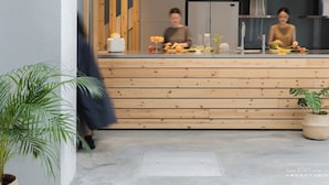 Une cuisine moderne avec des plans de travail en bois, un évier et une plante en pot.