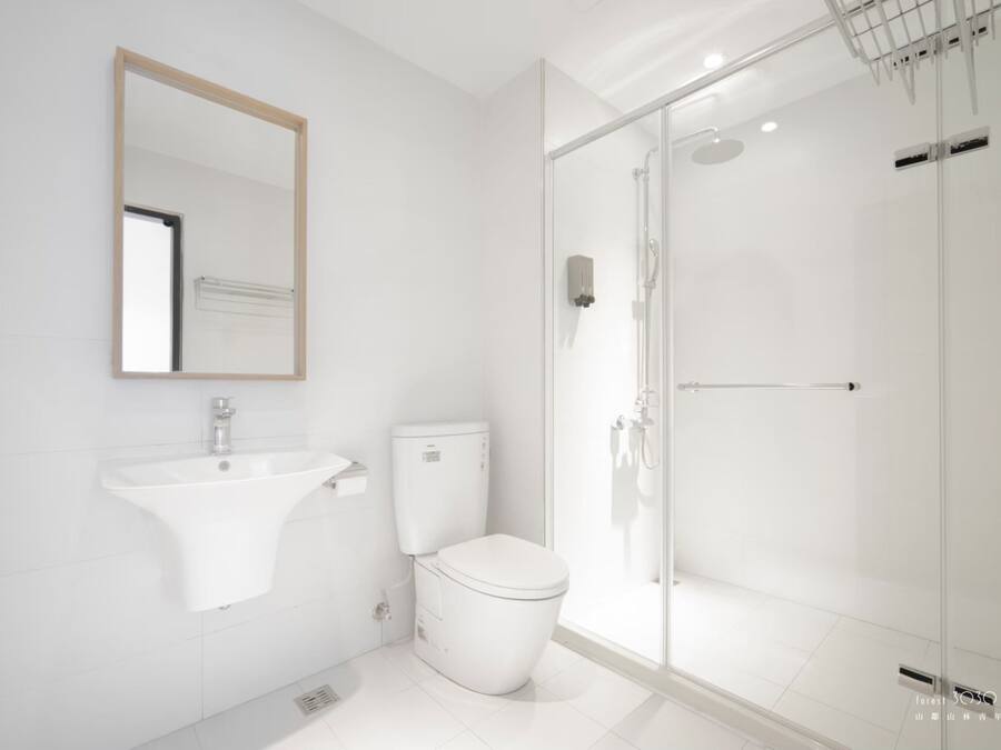 A modern bathroom with a sink, toilet, and glass-enclosed shower.