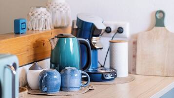 A kitchen counter with a hanging plant, a coffee maker, and various kitchen items.