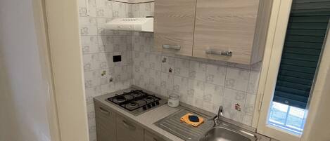 Een koelkast, een oven, een kookplaat, een koffiezetapparaat/waterkoker