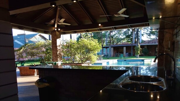 A modern kitchen with a large island, a built-in sink, and a view of a pool and outdoor area.
