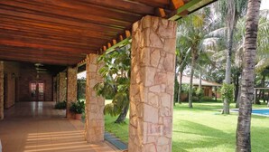 A covered walkway with stone pillars, leading to a building entrance.