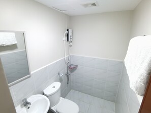 A small, clean bathroom with a toilet, sink, and shower. - COZY PLACE IN MACTAN W/ POOL, WIFI, NETFLIX - 10 min to the Airport! (Lapu-Lapu)