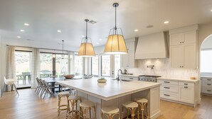 A spacious kitchen with a large island, pendant lighting, and a view of the outdoors. - Sleeps 25, Private Pool, Hot Tub & Courts, Playground (St. George)