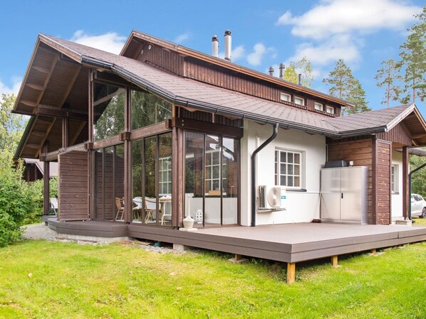 Ein modernes Haus mit einer großen Terrasse, einem Essbereich und einer Küche.