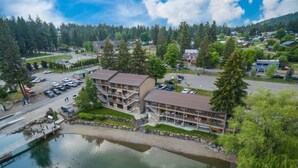 Un hotel sul lago con parcheggio, un molo e un edificio su più piani con balconi.