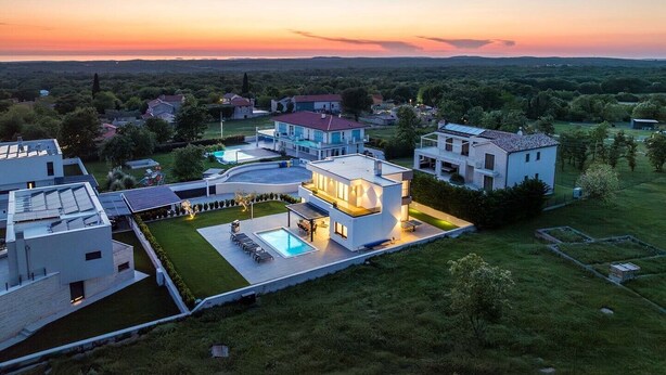 A modern residential area with contemporary houses, a swimming pool, and a well-maintained lawn. - Villa Ana Skicini in Jursici (Jursici)