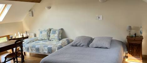 Un dormitorio con dos camas, un escritorio de madera y una mesita de noche.