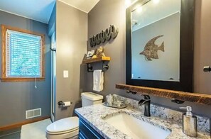 Een bad/douchecombinatie, handdoeken, toiletpapier