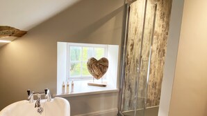 Un bagno moderno con una vasca freestanding, una finestra con vista e una parete decorativa in legno.