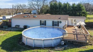 Il s’agit d’une propriété résidentielle dotée d’une grande piscine hors sol, d’une terrasse en bois et d’une cour arrière clôturée.
