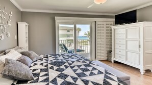 Une chambre avec un lit, un ventilateur de plafond, une télévision, une armoire et une vue sur l’extérieur.