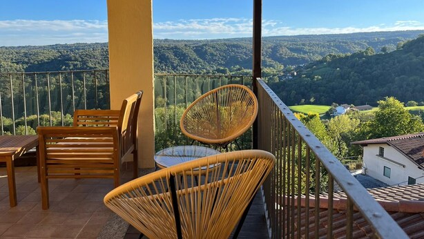 A balcony with wicker chairs and a wooden table, overlooking a scenic landscape with hills and a clear sky. - Cosy, pet Friendly Apartment in Netro, Piedmont (Netro)