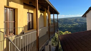 A yellow building with a balcony overlooking a forested valley. - Cosy, pet Friendly Apartment in Netro, Piedmont (Netro)