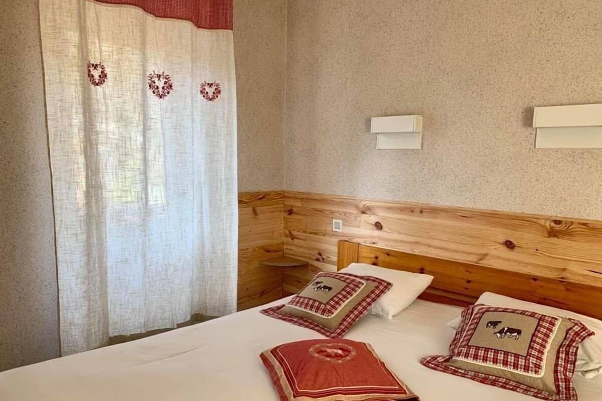 A bedroom with a wooden headboard, a bed with white bedding, and decorative pillows.
