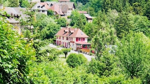 A hillside village with traditional houses, surrounded by dense forest. - Ô Caprice du Guiers (Saint-Pierre-de-Chartreuse)