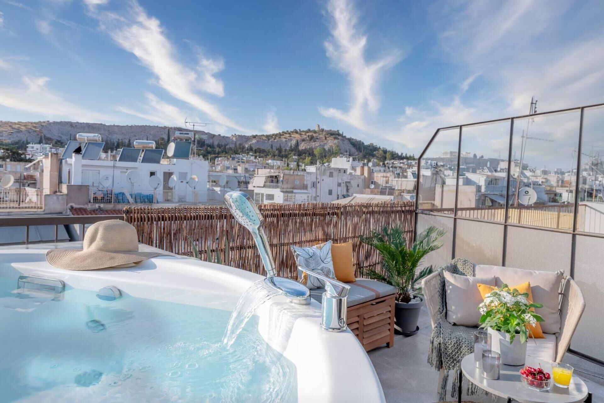 Terraço no telhado com hidromassagem, área de estar e vista para a paisagem urbana.