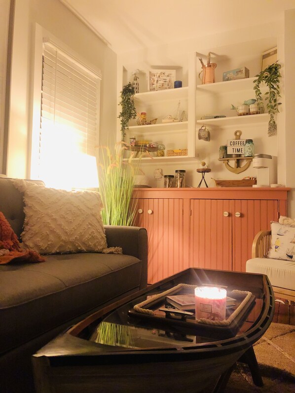 A cozy living room with a sofa, a coffee table, and a bookshelf. - Cozy, unique, historic registered cottage on the Corsica River! (Centreville)