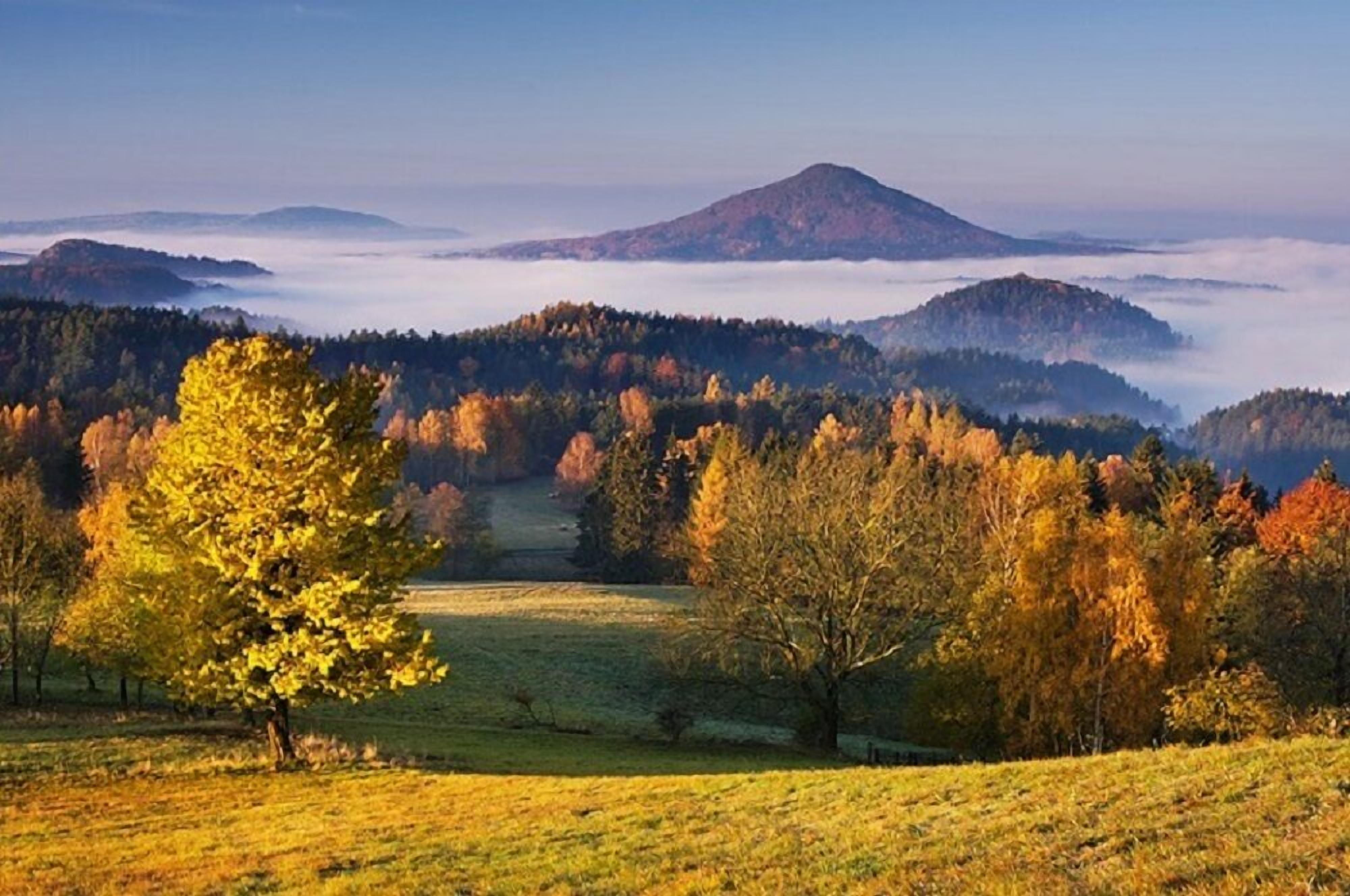 A mountainous landscape with autumn foliage and a clear sky.