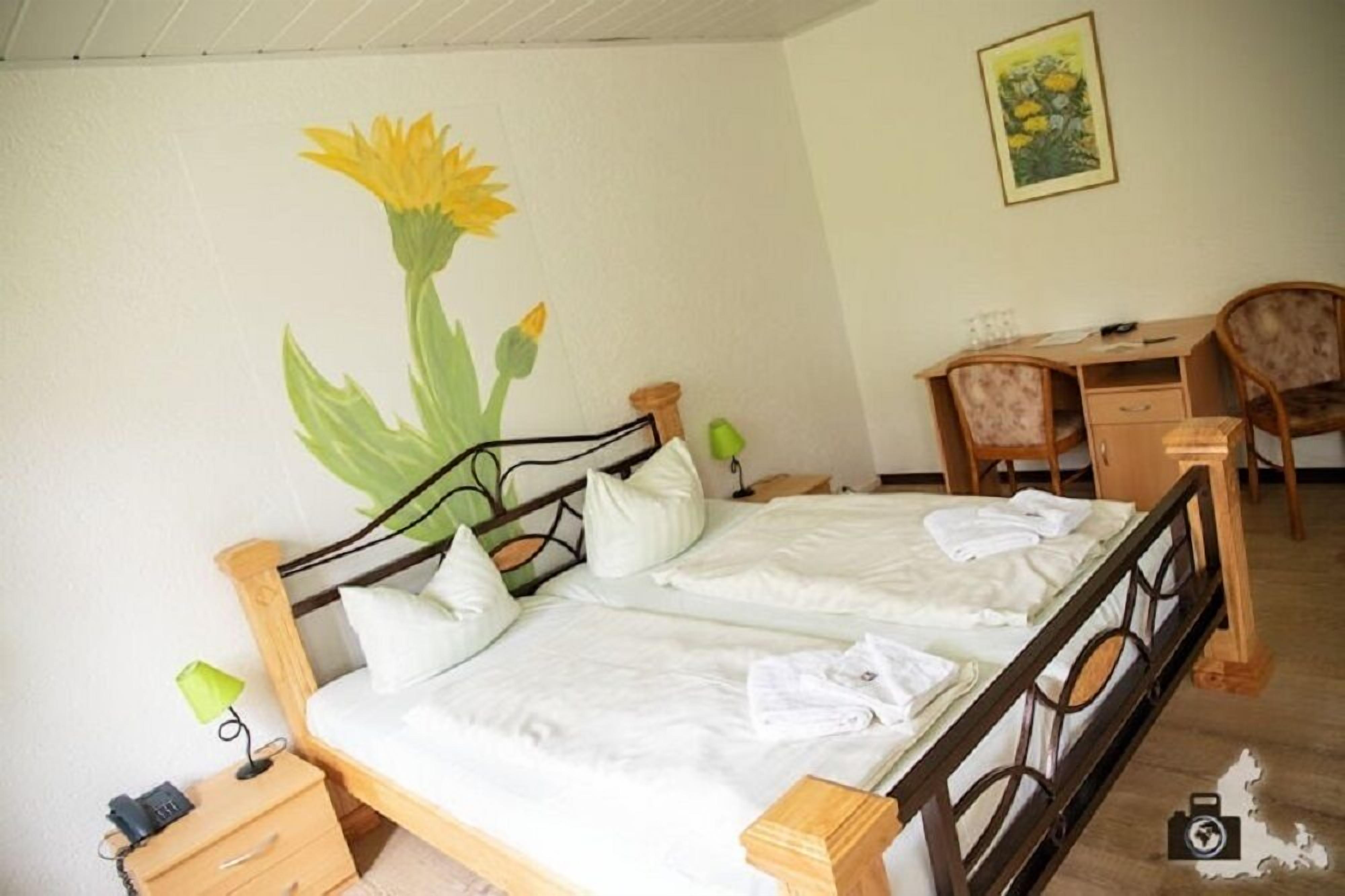 A bedroom with a bed, a desk, and a chair.