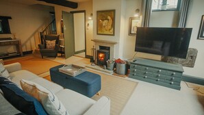 A living room with a fireplace, a television, and a sofa. - Rural Holiday Cottage With Log Burner (Buxton)