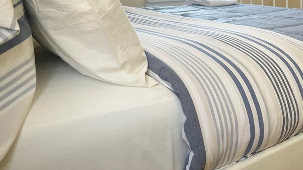 A bedroom with a bed, pillows, a window, and a view of the outside. - GREAT UPPER MANHATTAN APARTMENTS FOR GROUP AND FAMILIES (new york)