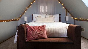 A bedroom with a bed, a brown chair, and a pillow with the word "Love" on it. - Meadow View Cottage (Manheim)