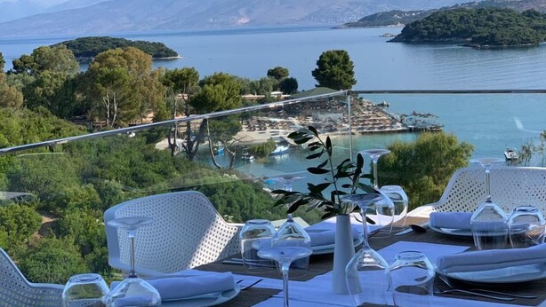 A table set for dining with a view of a lake and mountains. - Olive Hotel Ksamil (Ksamil)