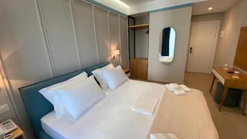 Una camera d'albergo con un letto grande, un comodino, uno specchio e un armadio.