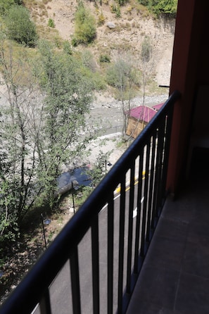 A balcony with a view of a river, trees, and a distant building. - Maajid Quba Hotel&Restaurant Sanatorium (Quba)
