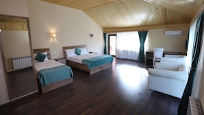 A room with two beds, a sofa, a radiator, and a window with curtains. - Maajid Quba Hotel&Restaurant Sanatorium (Quba)