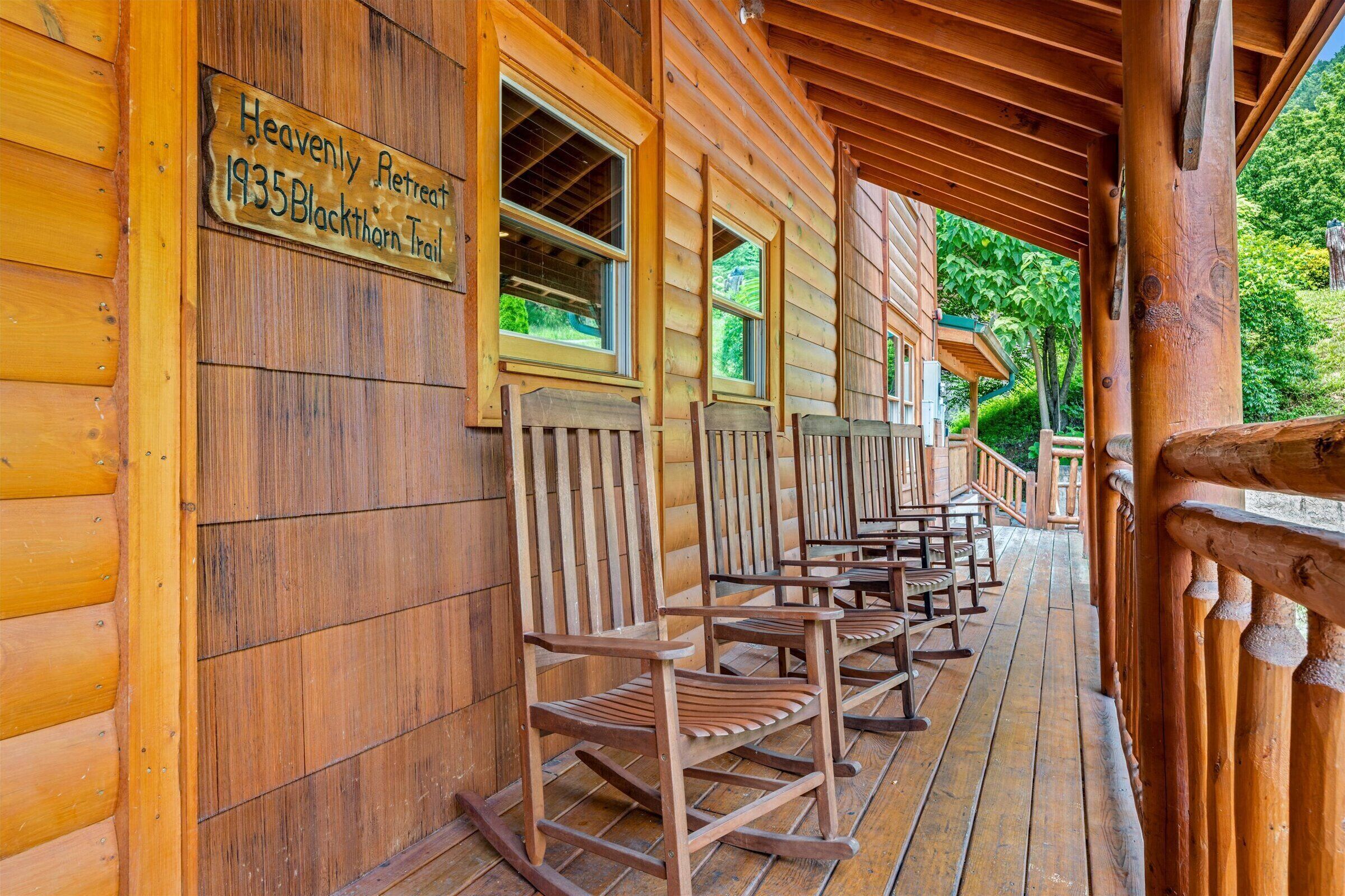 A wooden cabin with rocking chairs on the porch, a sign indicating 'Heavenly Retreat 1935 Blackthorn Trail'.