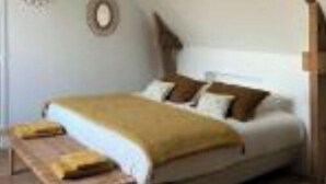 Ein Schlafzimmer mit einem Bett, einer hölzernen Bank und einer rustikalen Decke.