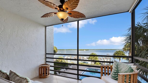 A balcony with a view of a marina and a pool. - Waterfront in Old Marco!  Beautiful unit!  Deluxe! (Marco Island)