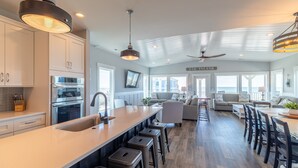 A spacious kitchen with a large island, stainless steel appliances, and a view of the ocean.