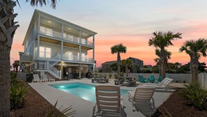A two-story building with a pool and outdoor seating.