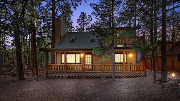 A log cabin with a wooden deck and multiple windows, surrounded by tall pine trees. - Tranquil Pinetop Getaway! w/Firepit, Grill, Deck, Pet-Friendly, Near Ski & Golf! (Pinetop)