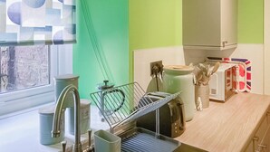 A kitchen with a window, a sink, a toaster, and a microwave. - A lovely hideaway in the heart of historic Crieff. (Crieff)