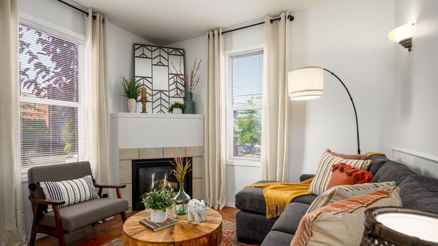 Ein Wohnzimmer mit Kamin, einer Couch, einem Sessel und einem Couchtisch.