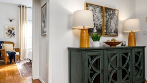 Ein Flur mit einem grünen Schrank, zwei Lampen und zwei gerahmten Bildern an der Wand.