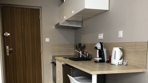 A modern kitchen with a wooden countertop, two white bar stools, a coffee maker, and a kettle. - The Green cocoon: Above the Alsatian vineyard (Turckheim)