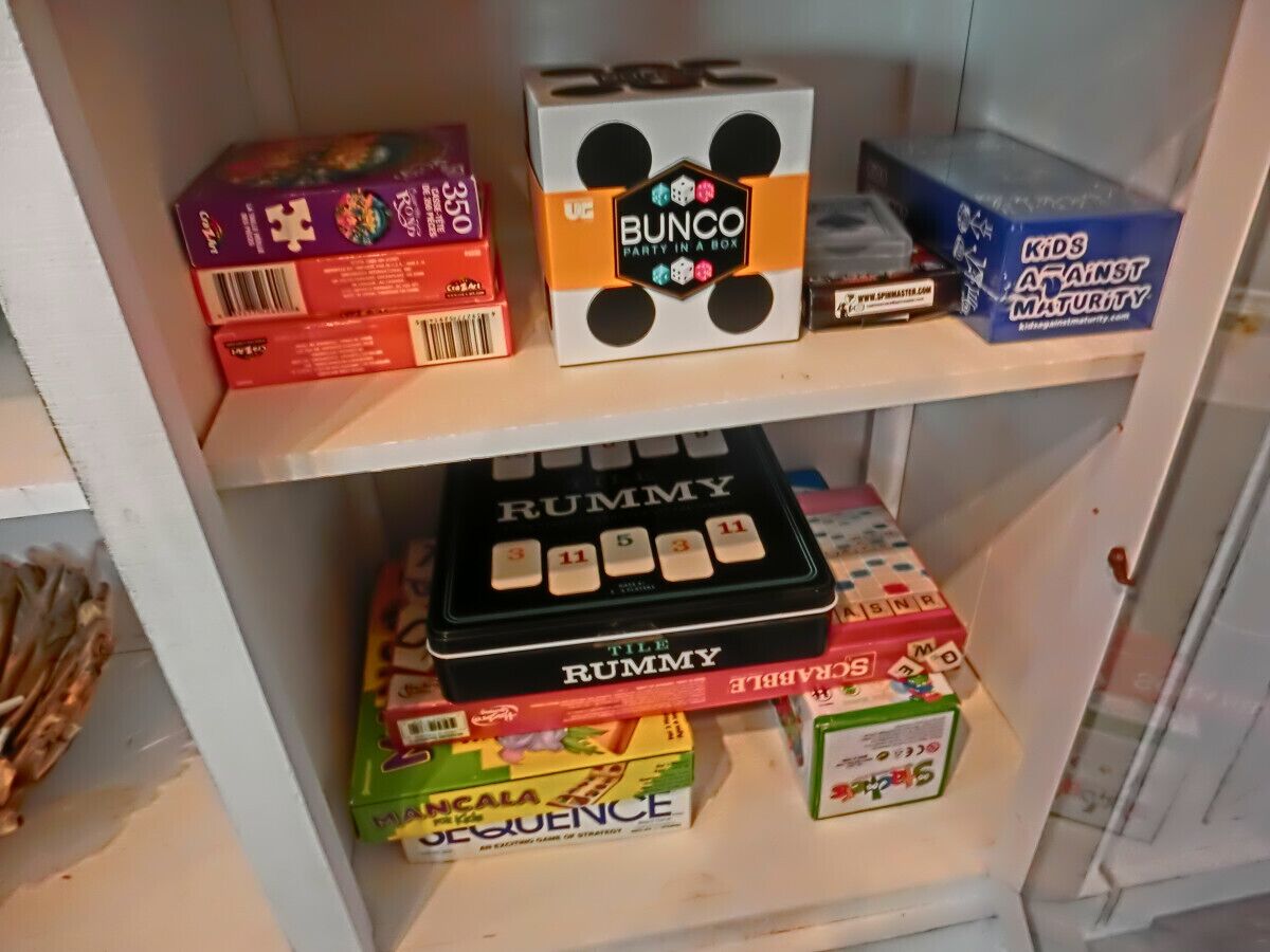 A shelf with various board games including 'Bunco', 'Tile Rummy', and 'Sequence'.