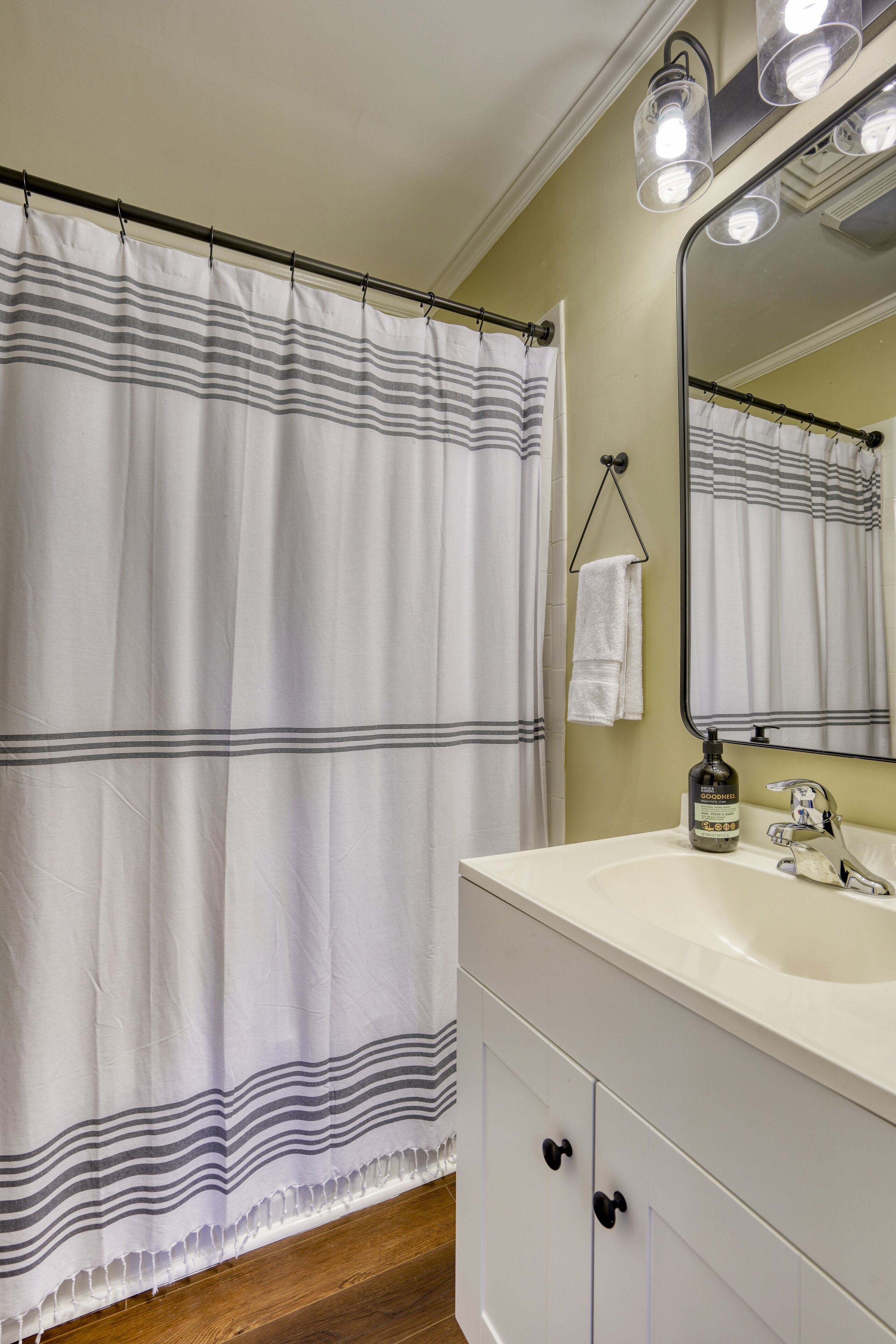 Een bad/douchecombinatie, een haardroger, handdoeken, zeep