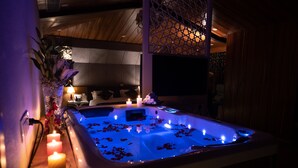 A spa area with a hot tub, candles, and a decorative plant. - Hotel Snowland Srinagar (Srinagar)