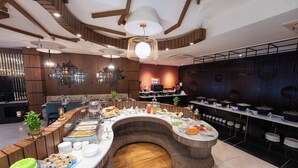 A buffet setup with various food items and a curved counter. - Hotel Snowland Srinagar (Srinagar)