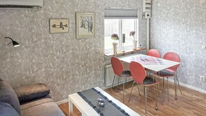 A modern living room with a sofa, a dining table with chairs, and artwork on the walls. - 2 bedroom nice home in Borrby (Borrby)