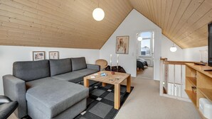 A modern loft apartment with a loft bed, grey sofa, wooden coffee table, and a dining area. - Beautiful home in Nørre Nebel (Nørre Nebel)